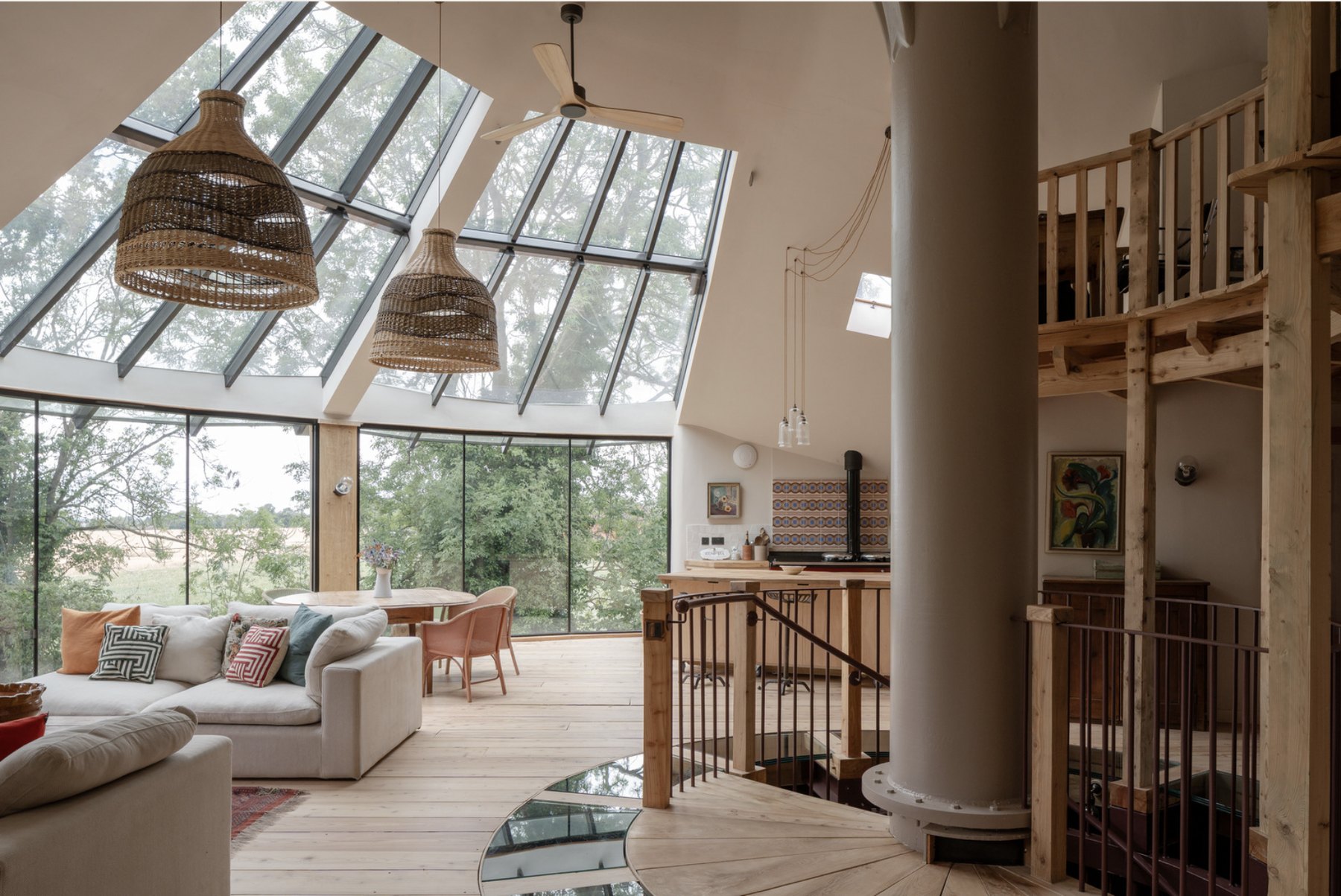 Open-plan top-floor reception with the central reclaimed-steel core, mezzanine, vaulted ceilings and pendant cluster